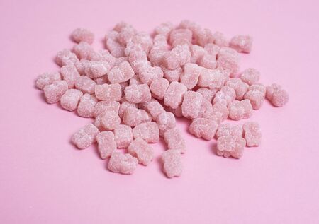 Pink vitamins in the shape of a bear on a pink background. It's like sweet marmalade in sugar....