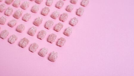 Pink vitamins in the shape of a bear on a pink background. It's like sweet marmalade in sugar. Vitamins for children.の写真素材