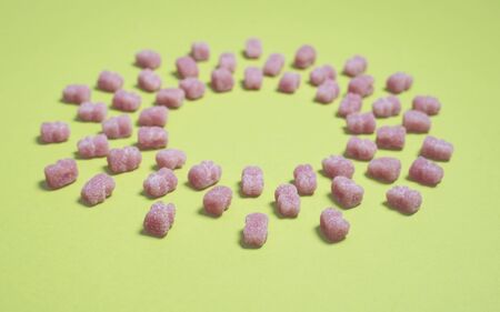 Pink marmalade bears on a light green background. Children's sweets.