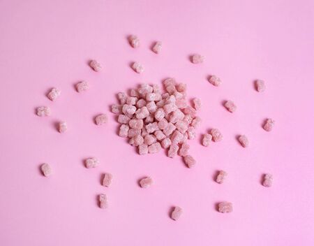 Pink vitamins in the shape of a bear on a pink background. It's like sweet marmalade in sugar....