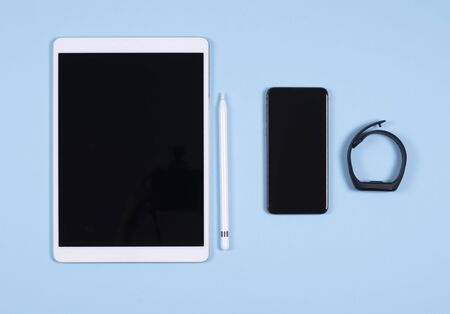 Modern gadgets on a blue background. Still life with modern technology on a plain blue background.