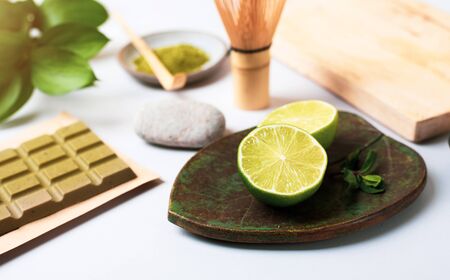 Green chocolate with matcha tea. Still life with green products: lime, matcha tea, green chocolate. The concept of healthy nutrition.の写真素材