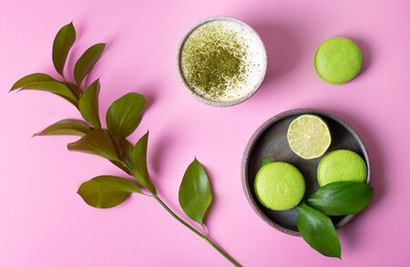 Macaroni dessert is bright green on a pink background. Matcha tea latte. Green food.