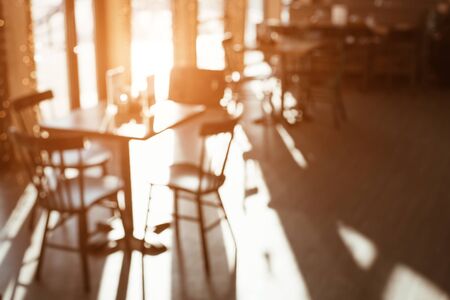 Interior of the cafe with large Windows. Sunny day. Empty tables in the cafe. Blurred background.の写真素材