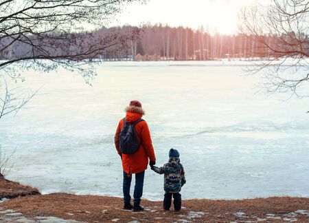 A young father and son are walking in nature. Lake, Sunny evening. Nice family photo.の写真素材
