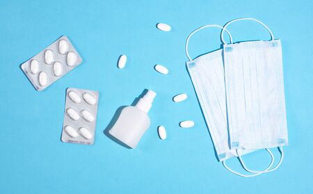 Concept of medicine. P revention of c oronavirus. Medical masks, vitamins, antiseptic on a blue background.の写真素材