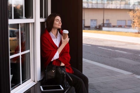 Young beautiful woman on a walk. Delicious coffee and a warm blanket.の写真素材