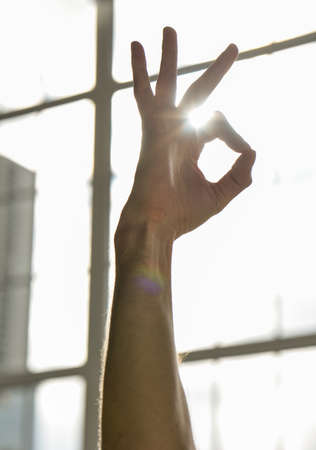 Hand close-up on the background of the window. A gesture from yogaの写真素材