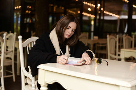 A young woman in a cafe with a notebook. Plans for the new year.の写真素材