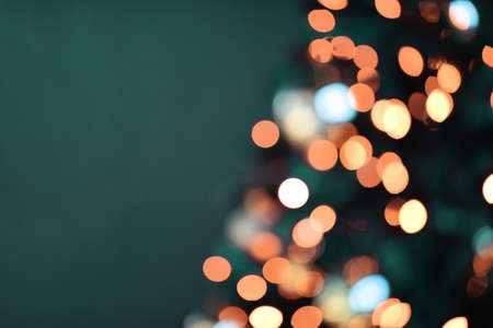 Blurred background. Christmas background with lights. Holiday light bulbs. Blurred silhouette of a Christmas treeの写真素材