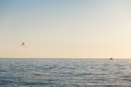 A motor boat pulls the parachute, which two people over the sea.の写真素材