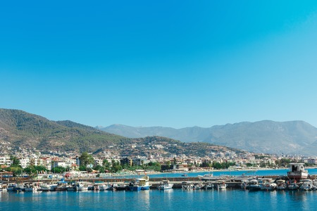 The port with ships near the shore of Antalya. Mountain with houses on it, the view of the city. yachts and other boats.の写真素材