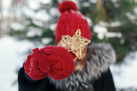 Girl looking through a Christmas toy. Winter and Christmas tree backgroundの写真素材