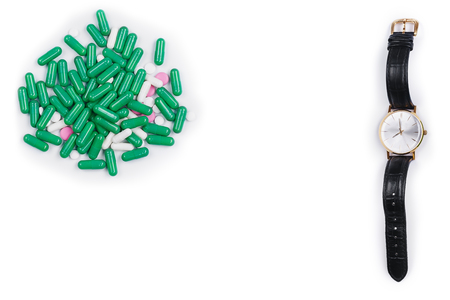 Watch lie down with pills on white backgroundの写真素材