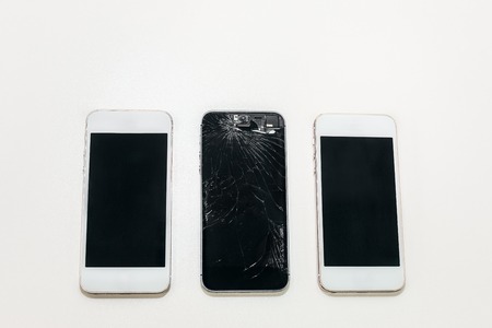 one black broken phone and two white whole next