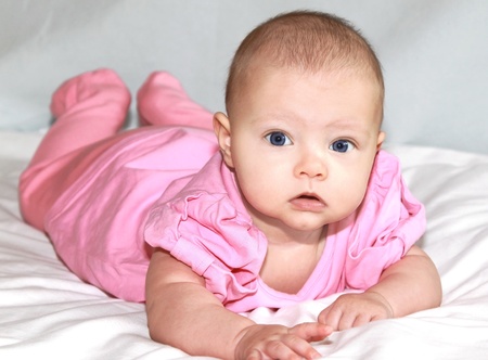 Beautiful baby girl lying and looking in camera