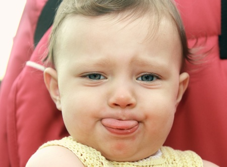 Fun baby showing the tongue playing up  Closeup portrait