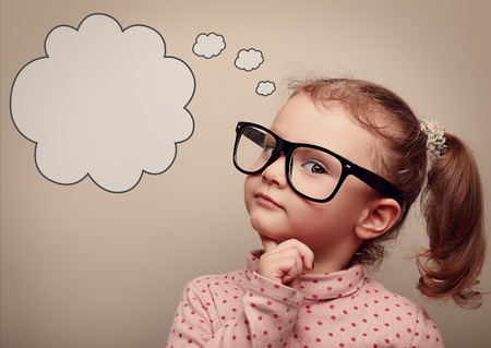 Smart kid in glasses thinking with speech bubble above with empty copy space. Vintage portrait Smart kid in glasses thinking with speech bubble above with empty copy space. Vintage portrait
