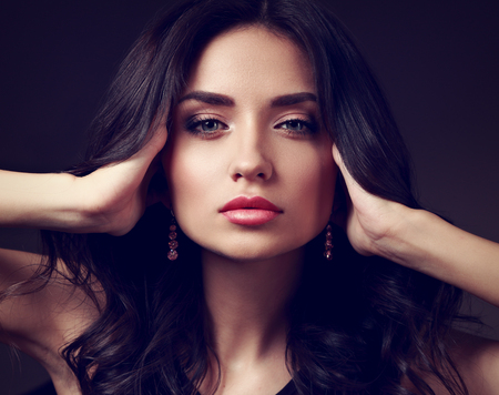 Beautiful makeup woman with pink lipstick and long curly hair looking calm. Closeup fashion portrait. Toned artの写真素材
