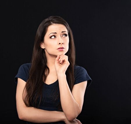 Very concentrated unhappy business woman looking up and find the solution on problem situation....