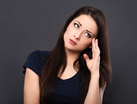 Very concentrated unhappy business woman holding the head the hand and find the solution on problem...