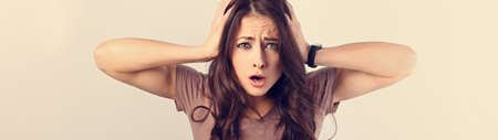 Angry young surprising business woman holding the head the hands with big eyes. Fun humor casual...
