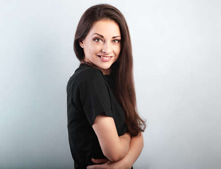 Happy toothy smiling sporty woman hugging herself with natural emotional enjoying face on light blue studio background. Love concept of yourself bodyの写真素材
