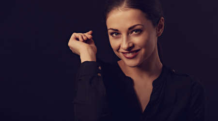 Business strong thinking woman with natural makeup looking with hand near the face arms in black...