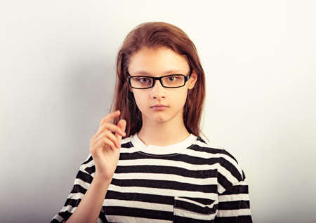 Serious girl with long hair style in fashion eyeglasses in t-shirt making dreaming physiognomy and looking Closeup toned vintage portraitの写真素材