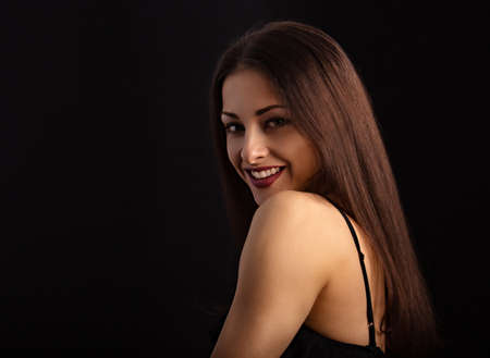 Beautiful makeup woman with long hair looking happy on black background. Closeup portrait of natural happiness. Toned colorの写真素材
