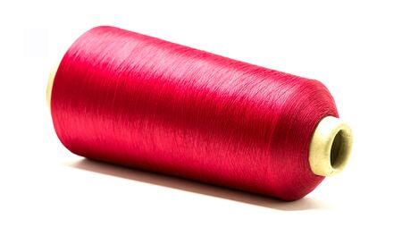 Red spool or reel of thread for sewing on white background using for fabric, textile industry and...