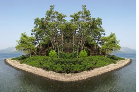 island in aegean sea covered with trees and bushesの写真素材