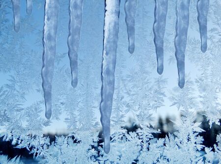 snowflakes ice pattern with sunlight on winter window glassの写真素材