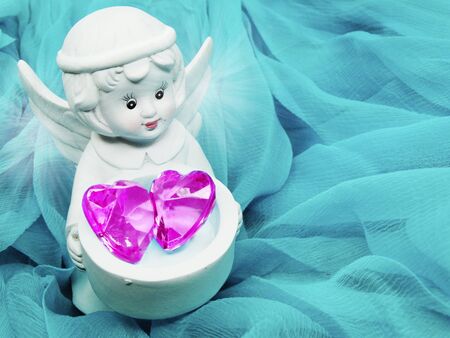 gem crystal heart in angel's hands on silky cloth love conceptの写真素材