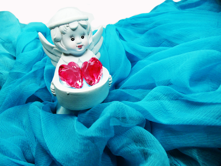 gem crystal heart in angel's hands on silky cloth love conceptの写真素材