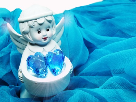 gem crystal heart in angel's hands on silky cloth love conceptの写真素材