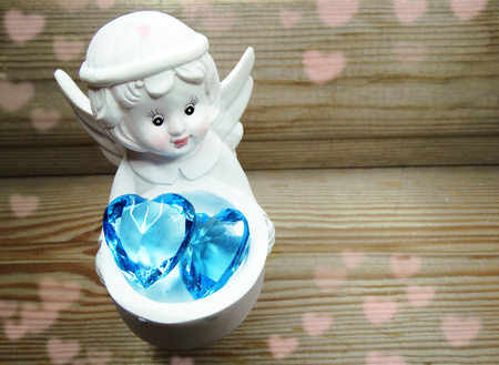 gem crystal heart in angel's hands on old wood background love conceptの写真素材