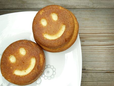 creative baked food cakes funny faces with smileの写真素材