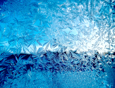 snowflakes ice pattern with sunlight on winter window glass