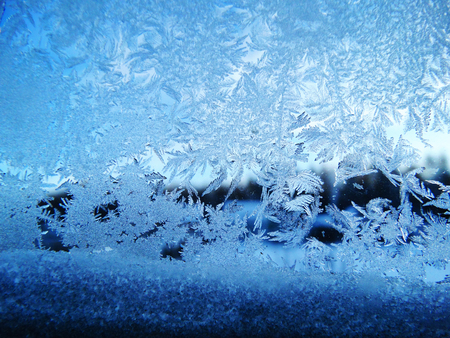 snowflakes ice pattern with sunlight on winter window glass