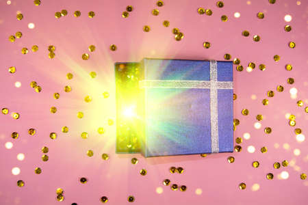 Opening gift blue box with magical special effects lights and golben sparklesの写真素材