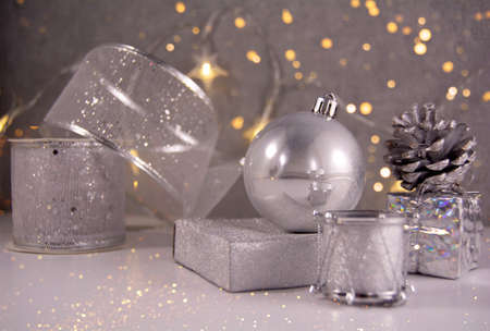 Silver christmas decoration ball, ribbon, cone, drum and golden lights. Front view stile.
