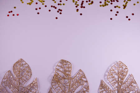 Holiday decorations: gold leaf, red and gold sequins. Minimal, top view, flat lay, copy space