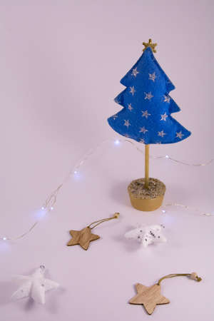 Christmas tree made of felt, wooden and plastic christmas toys and garland on a white background. Holiday concept. Front viewの写真素材
