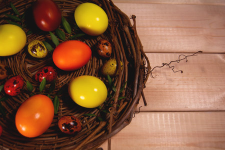 Easter eggs in a basket on wooden backgroundの写真素材