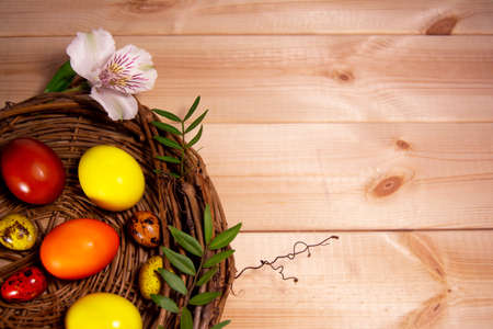 Easter eggs in a basket on wooden backgroundの写真素材