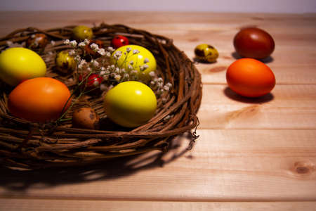 Easter eggs in a basket on wodden tableの写真素材