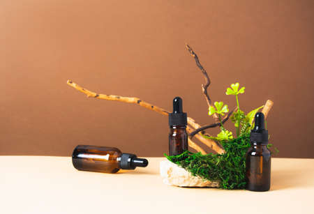 Set of bottles with serum or oil with natural materials on brown and beige backgroundの写真素材