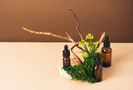 Set of bottles with serum or oil with natural materials on brown and beige backgroundの写真素材