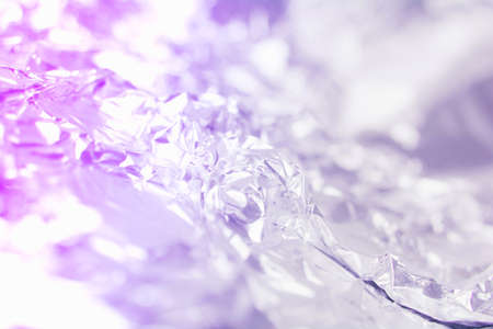 Textured neon background of crumpled metallic shiny foil. Light gradient holography. Abstract backdrop for your projects. Copy spaceの写真素材